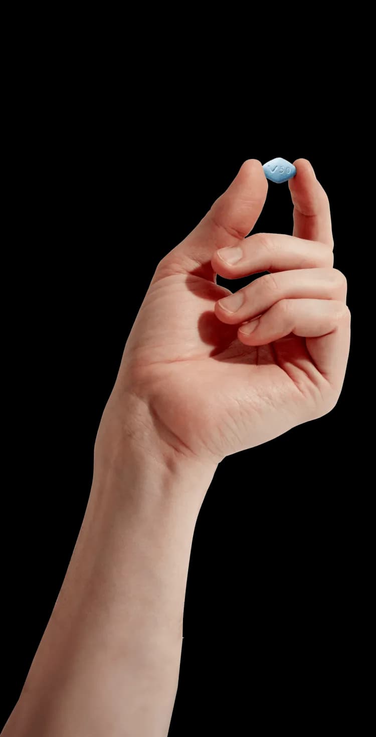 Hand holding a blue pill